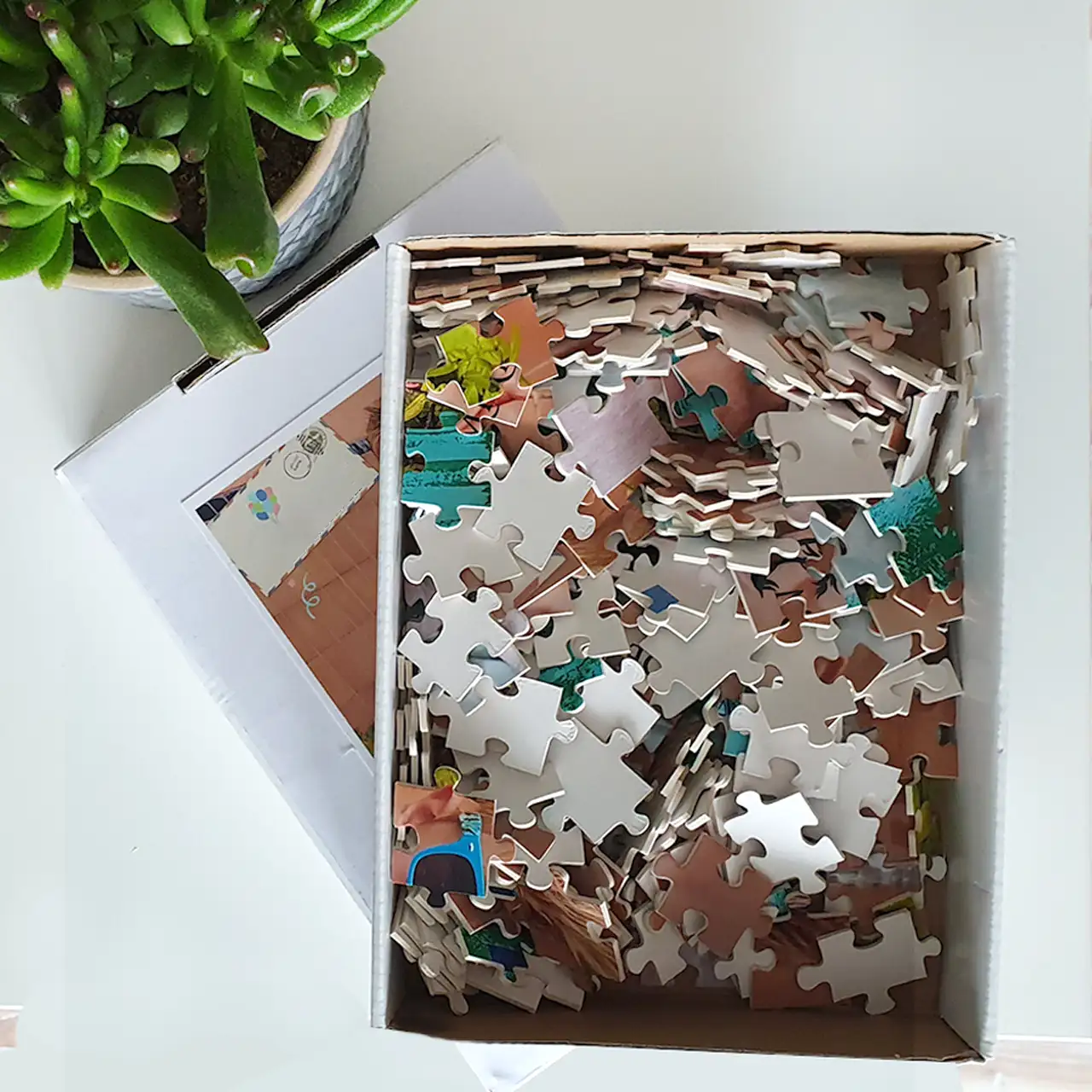 Photo puzzle pieces in white gift box A look inside the packaging of a photo jigsaw from Morrisons Foto – colourful pieces ready to be assembled.