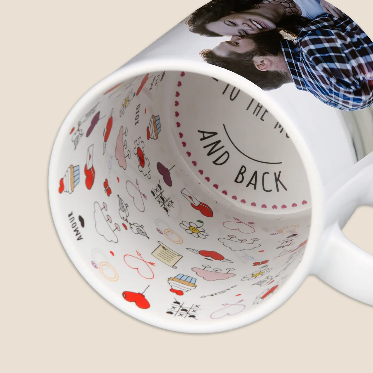 Close-up of an „I love you“ mug lying on its side. There are many lovely icons printed all over the inside of the mug. Just perfect to give away as a special gift for your significant other.