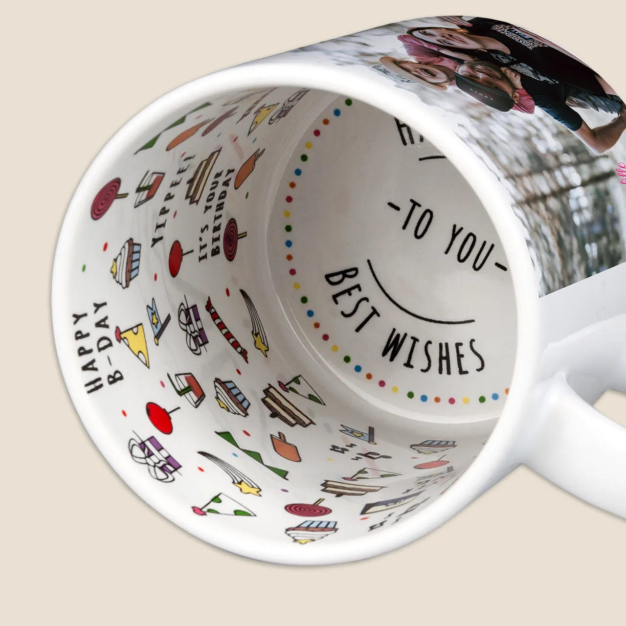 Birthday cups, festive birthday motifs and joyful slogan on the inside Close-up of a happy birthday mug lying on its side. There are many cheerful icons printed all over the inside of the mug. Just perfect to give away as a birthday gift.